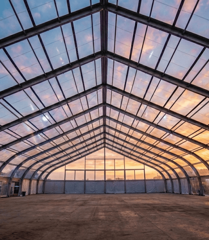 Large arched fabric structure with steel framework and translucent membrane roofing for events and sports